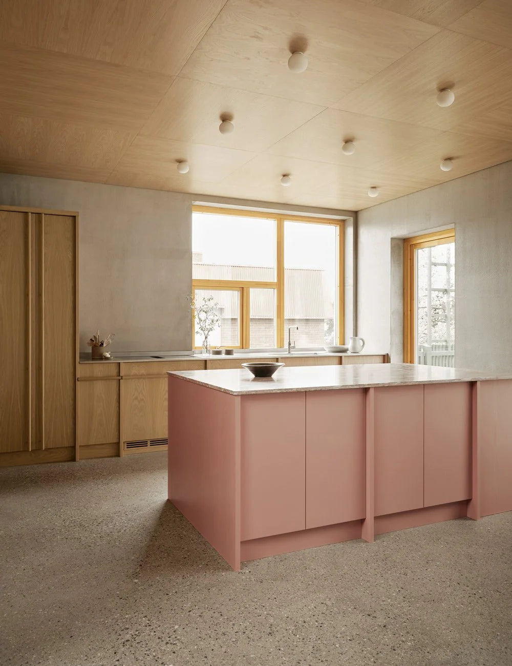 Light oak kitchen with pink kitchen island