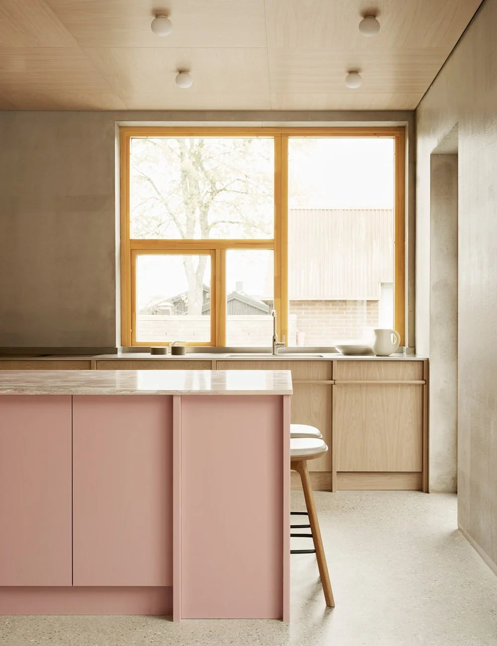 Light oak kitchen with pink kitchen island
