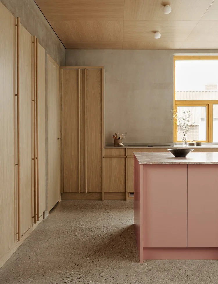 Light oak kitchen with pink kitchen island
